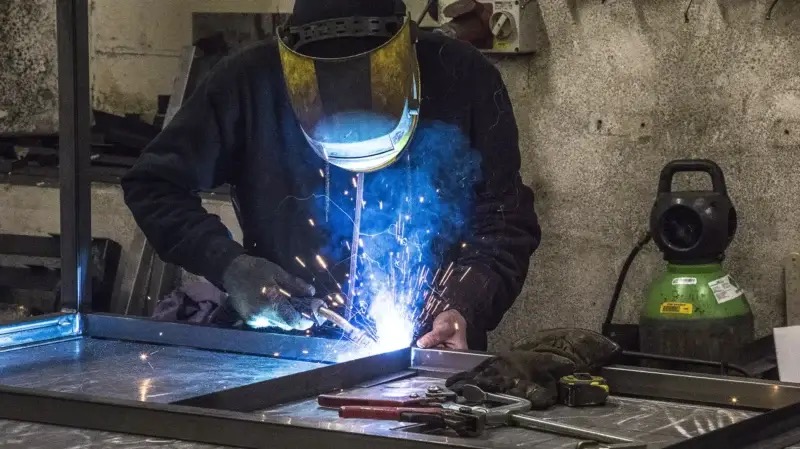 Welder fabricating workbench frames at UK Workbenches
